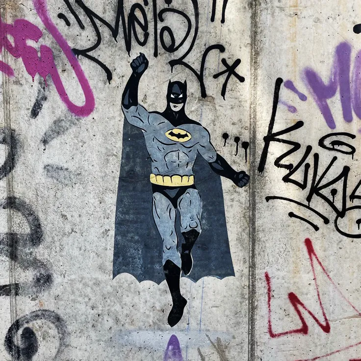Illustrasjon av Batman sprayet på en lys murvegg ned tagging