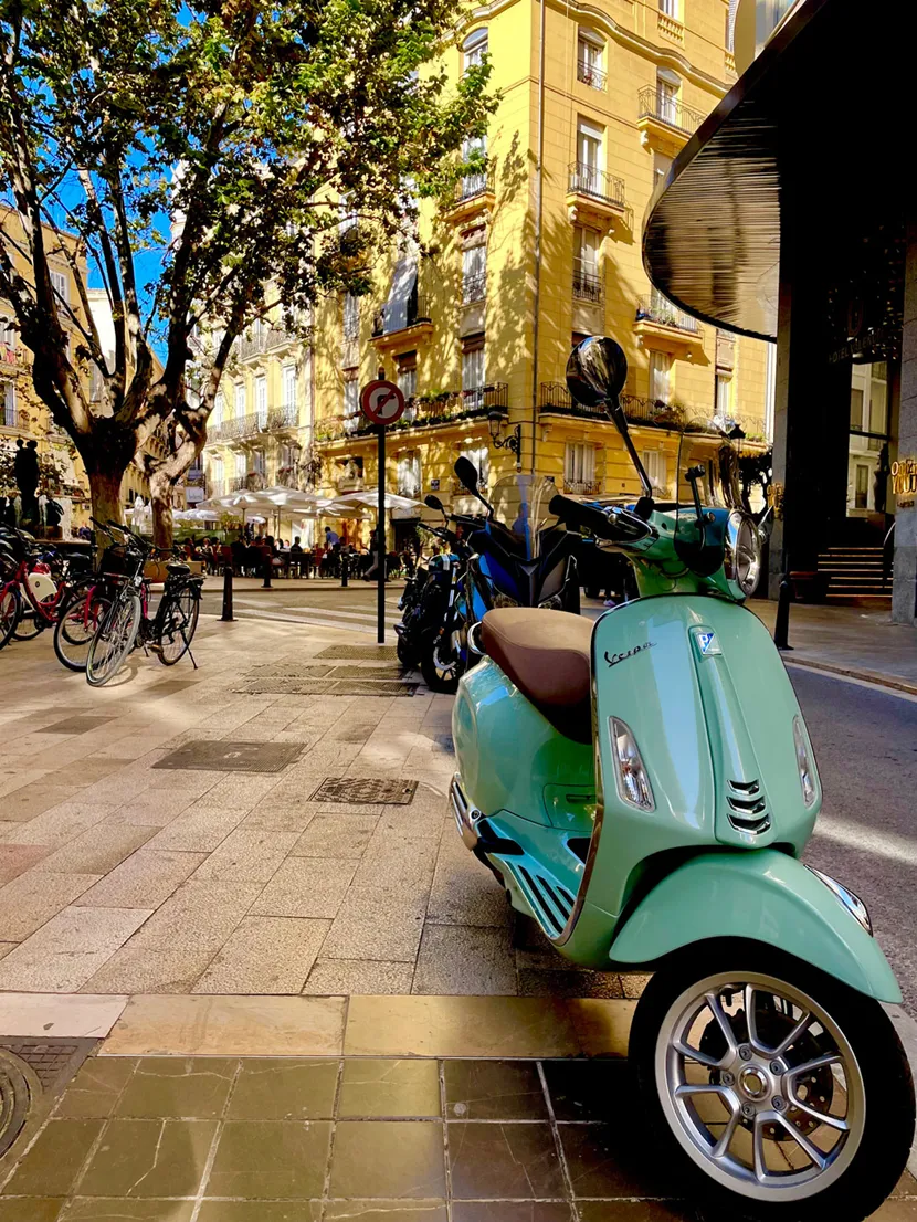 En turkis Vespa på et torg i Valencia.