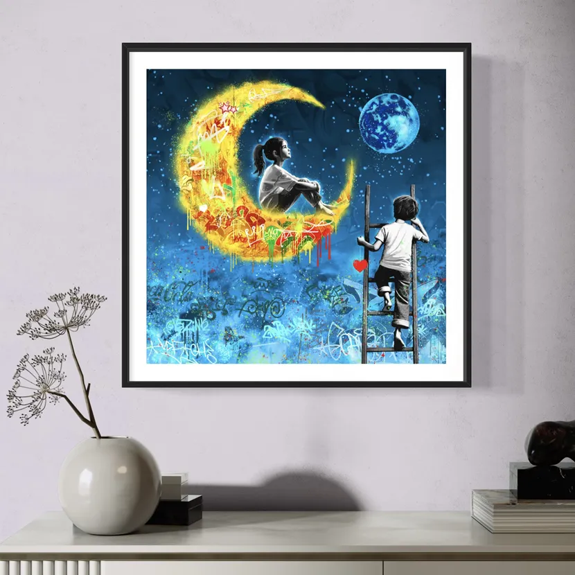 Bildet Stargaze henger på en lys grå vegg. Motivet er en gul halvmåne på en mørk blå himmel, ei jente sitter på halvmånen, mens en gutt klatrer opp på en stige.